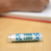 Clear Personalized Lip Balm in Tropical Smoothie on a desk